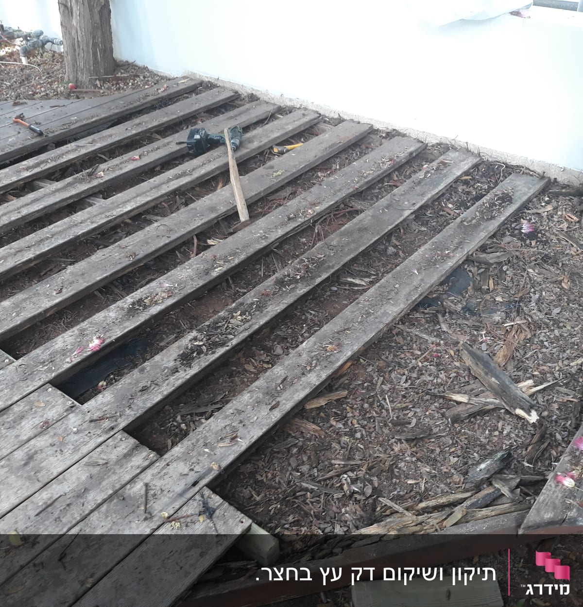 קרשים מעץ בגינה עם כלי עבודה על הקרקע